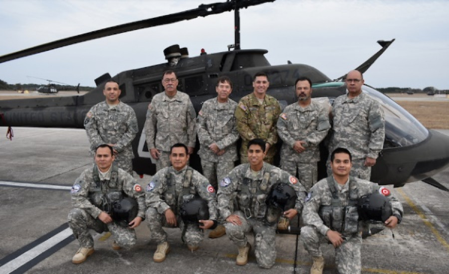 Los oficiales FAP junto a sus instructores estadounidenses y la plataforma de instrucción, el OH-58 Kiowa. Foto: Fuerza Aérea del Perú.