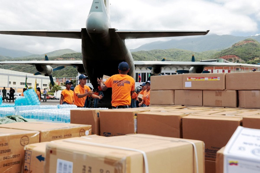 Miembros de Protección Civil cargando un avión militar Y-8F-200W con ayuda humanitaria para Dominica. Foto: Agencia Venezolana de Noticias.