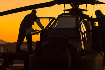 Operarios trabajando en un helicóptero de ataque AH 64 Apache. Foto. Boeing