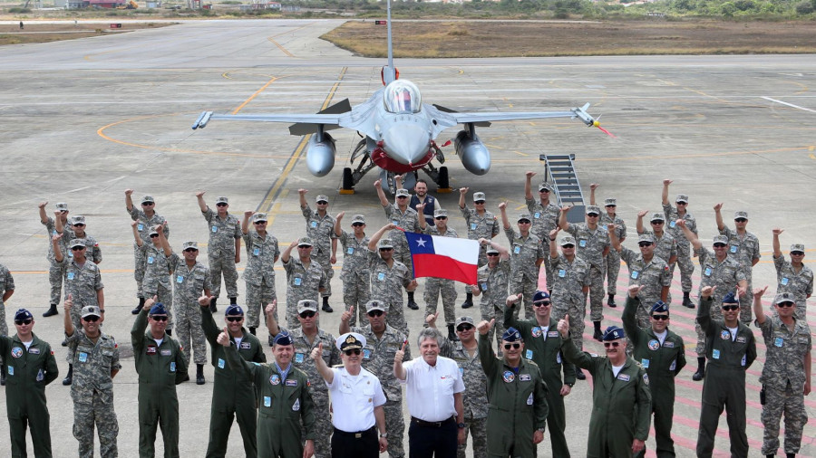 El ministro Espina junto a la delegación chilena y un F-16 MLU en Cruzex 2018. Foto: Ministerio de Defensa de Chile