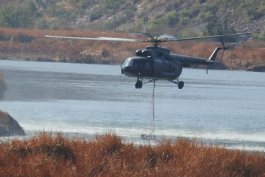Helicóptero Mi-17 de la FAP carga agua con helibalde en laguna cercana al incendio. Foto: Andina Agencia Estatal de Noticias.