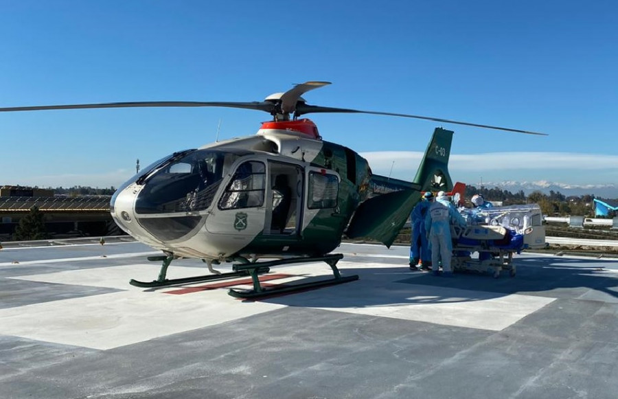 La tripulación de la Prefectura Aérea embarca al paciente Covid en el Airbus H135. Foto: Carabineros