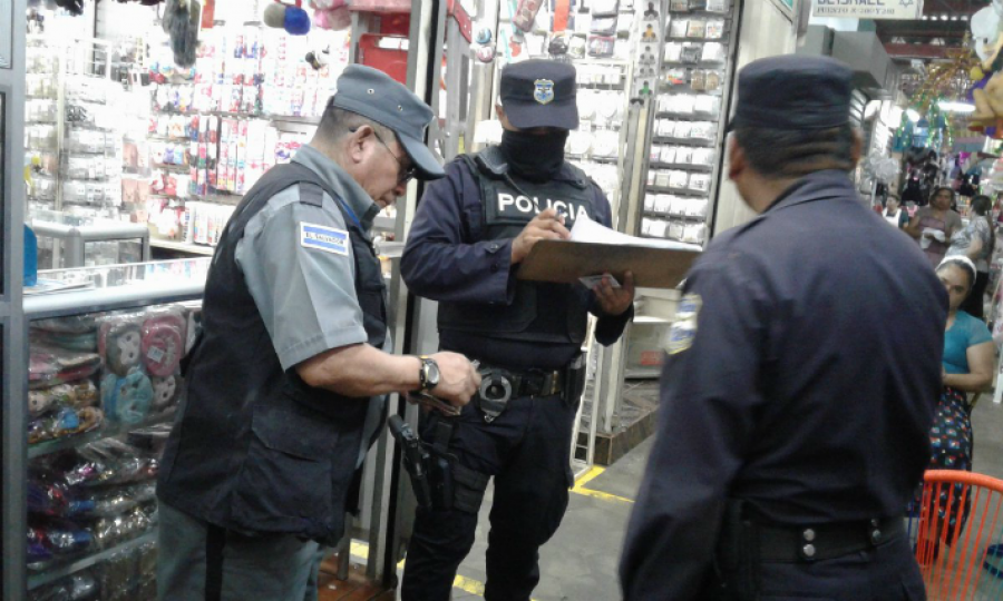Agentes policiales revisan documentos de autorización a un vigilante privado izquierda. Foto: Policía Nacional