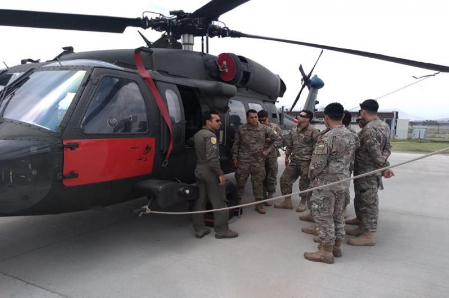 Comandos de Aviación de la FACh junto a un MH-60M Black Hawk con esquema antártico. Foto: FACh