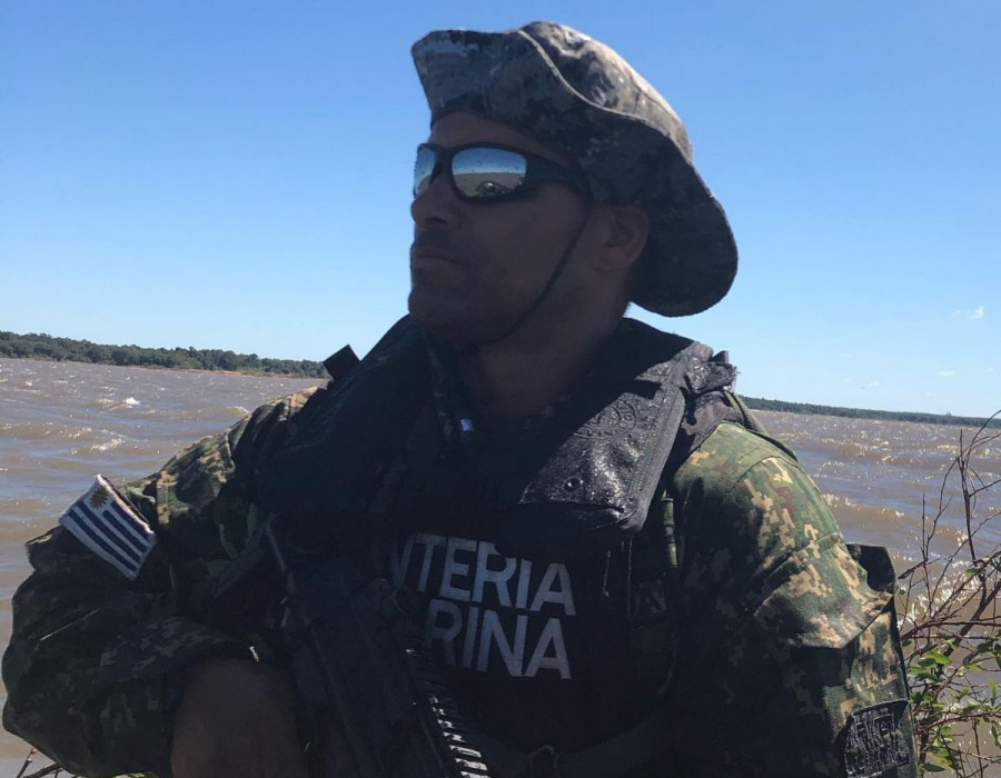 Infante de Marina uruguayo con su uniforme pixelado, en vuelo se observa un B200 naval Foto: Armada de Uruguay