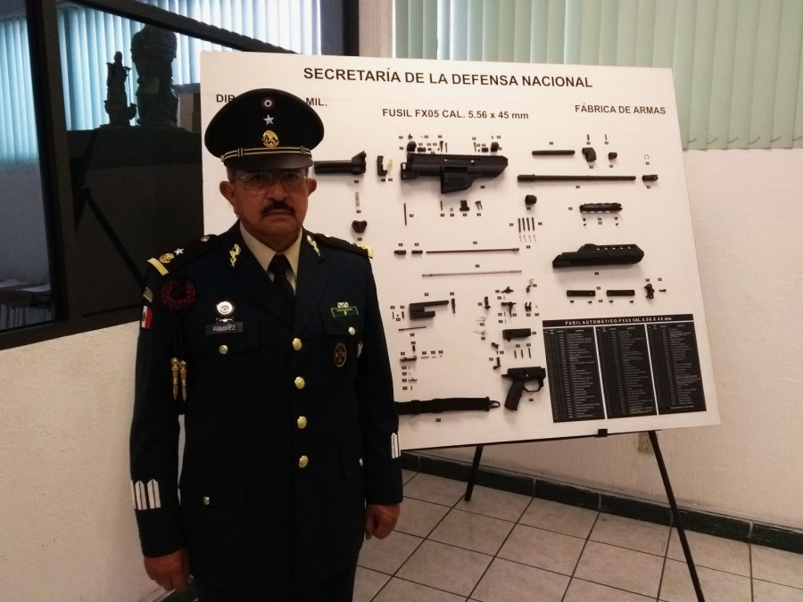 El general Ottilio Ramírez posa junto a un póster del diseño del fusil FX-05