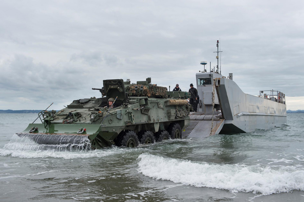 Corporal Robert Hosking drives a LAV ashore from a landing craft foto NZ Army