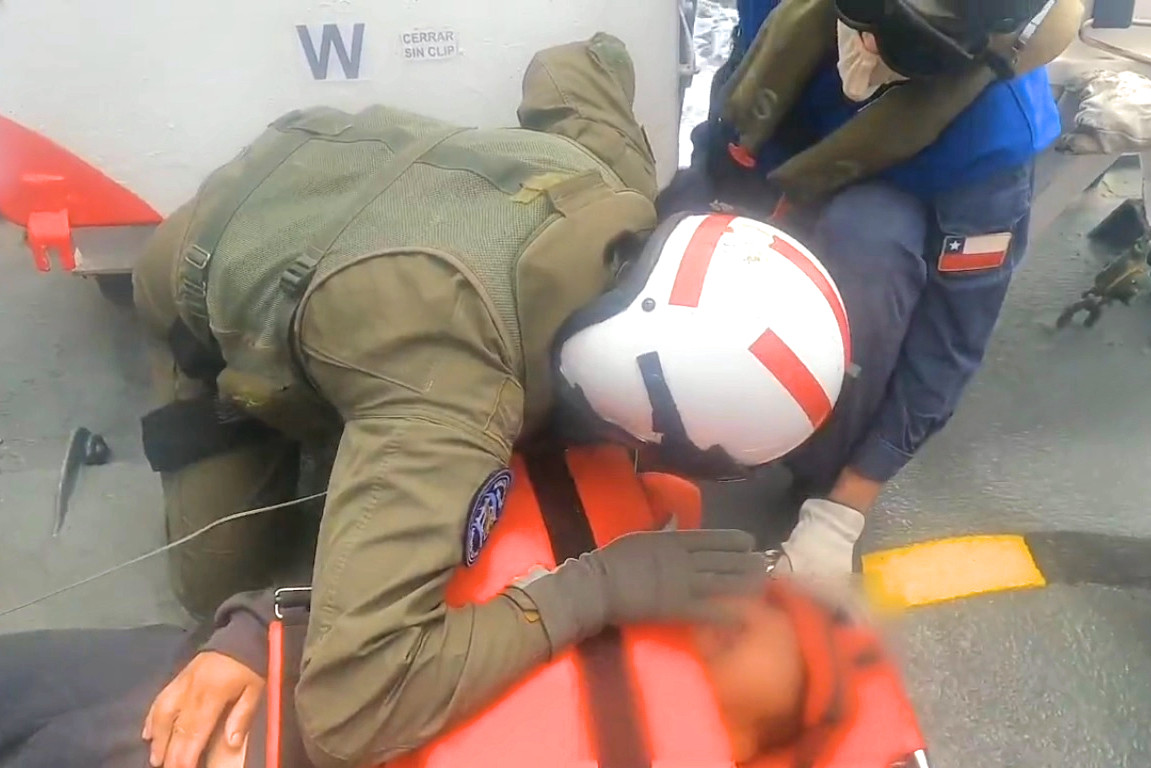 El tripulante del pesquero Marisol II recibe atenciu00f3n mu00e9dica del enfermero naval del helicu00f3ptero Naval 54 en la LPC Salinas Imagen Armada de Chile