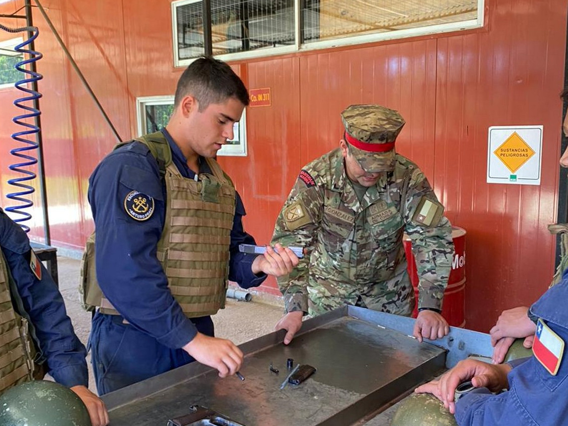 Cadete de segundo au00f1o realiza proceso de desarme de pistola baja la atenta mirada de un instructor del Cenbim Firma Escuela Naval Arturo Prat de la Armada de Chile