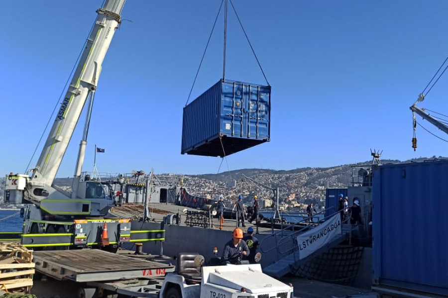 Grúa pluma carga un contenedor en la barcaza LST 92 Rancagua en el molo de abrigo de Valparaíso Firma Armada de Chile