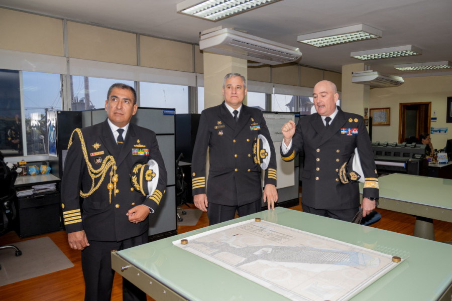 El agregado naval de Perú en Chile y el comandante del BAP Carrasco escuchan una presentación del director del SHOA durante su visita a ese organismo técnico Firma Armada de Chile
