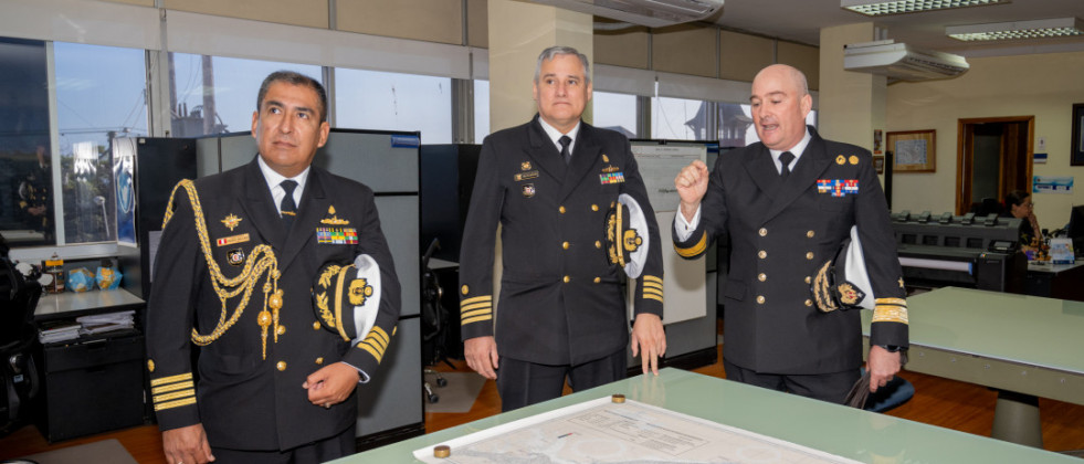 El agregado naval de Perú en Chile y el comandante del BAP Carrasco escuchan una presentación del director del SHOA durante su visita a ese organismo técnico Firma Armada de Chile