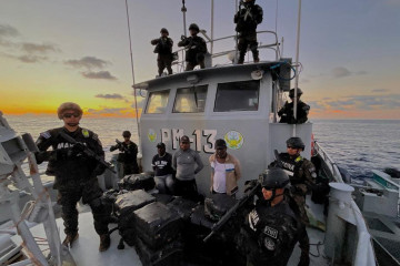 Miembros de la Marina Nacional de El Salvador custodian a los detenidos con un millonario alijo de droga