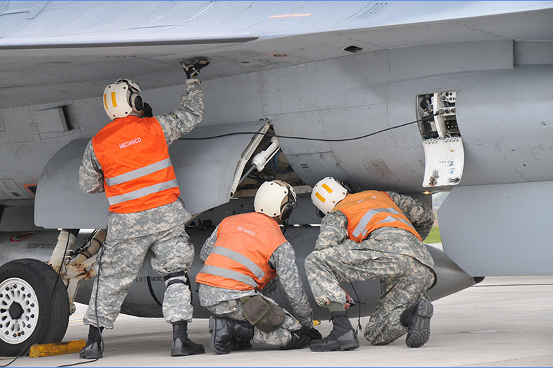 Mecánicos de aviación inspeccionando un caza F 16 Fighting Falcon Firma FACh