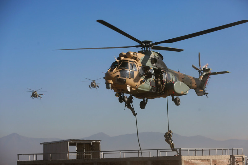 Descenso de operadores desde un Cougar escoltado con helicópteros MD 530F Firma Ministerio de Defensa Nacional de Chile